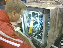 Student Scott Wilson checks some of CajunBot's electronics.